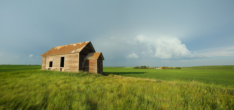 An abandoned decaying home on a stormy summer evening in Alberta, Canada.
