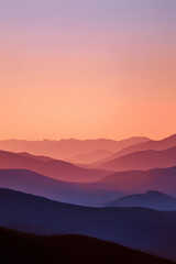 Obraz premium Layered Mountain Silhouettes at Sunset with Warm Orange Pink Gradient Sky Panoramic Serene Landscape