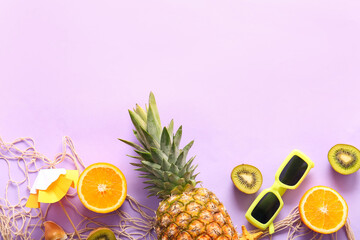 Fototapeta premium Fresh pineapple with orange, kiwi, umbrella and sunglasses on lilac background