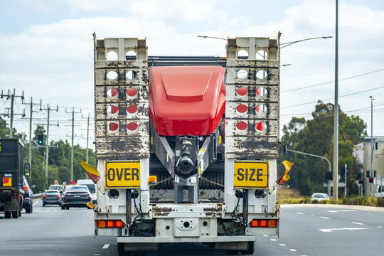 Heavy transport truck carrying an oversized industrial load with &ldquo;oversize&rdquo; warning signs driving on a public road in Australia. Logistics, freight transportation, and road safety in infrastructure