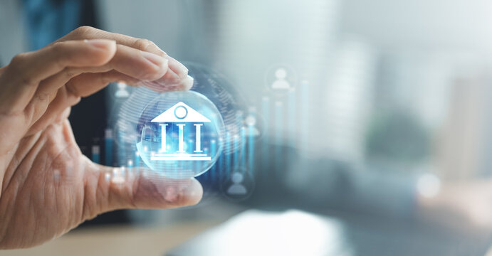 Hand holding digital bank icon with financial data interface, concept of online banking service, secure money transfer and financial technology in global economy.