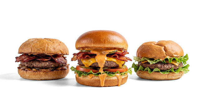 three gourmet burgers with bacon, cheese, lettuce, and sauce, isolated on a transparent background.