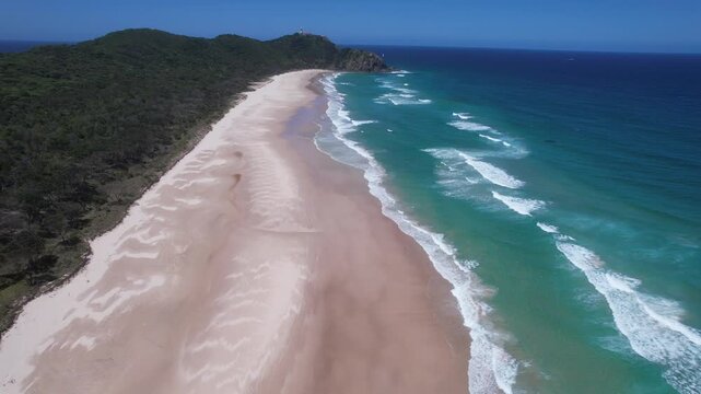 Empty Tallow Beach With View Of Cape Byron Lighthouse In Distance. Byron Bay, Australia. ascending drone shot