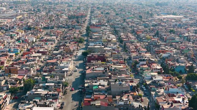 Low-level aerial of residential streets in Ecatepec with traffic and pedestrians