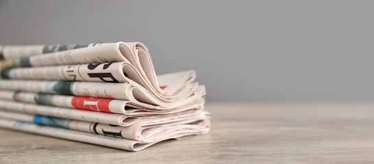 Folded newspapers wooden table, closeup. Banner for design