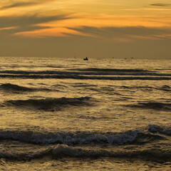 Scenic golden sunset over calm ocean waves with glowing horizon