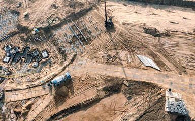 pile driver works to set concrete piles for foundation of new apartment building. construction site aerial view.