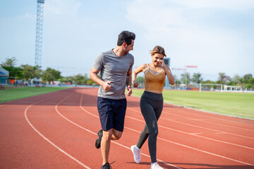 Fototapeta premium Diverse young man and woman running exercising together at stadium. 