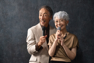 マイクを持って歌を歌うシニア男女　ライフスタイルイメージ