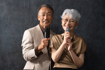 マイクを持って歌を歌うシニア男女　ライフスタイルイメージ