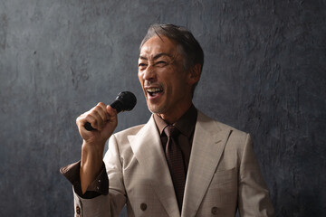 マイクを持って熱唱するシニア男性　ライフスタイルイメージ