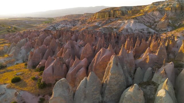 Goreme, Nevsehir, Turkey. Low altitude flight over Devrent Valley revealing intricate details of whimsical rock formations in sunset glow.. Aerial View