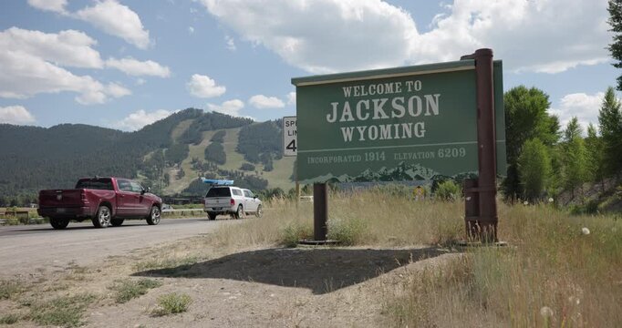 Welcome to Jackson Wyoming Sign with Passing Traffic in Summer