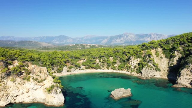 Stunning aerial view of Alonaki Fanariou beach with turquoise waters, surrounded by rocky cliffs and lush green forest in Greece.