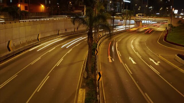 A timelapse of a 6 lane road called "Javier Prado". Many cars drive past with motion blur. Located in San Borja district of Lima, Peru.