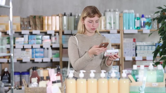 Girl in winter clothes scans code on package of paracetamol pills to check the expiration date. High quality 4k footage