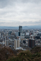 Obraz premium Modern cityscape around Kumamoto Station under a cloudy sky in February 2026