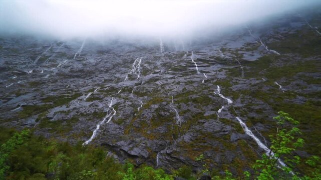 Milford Sound Homer Tunnel Headwall Darran Mountain Range West Portal waterfalls sheer rock face weather clouds rainy Spring season New Zealand Aotearoa November December South Island Southern Alps