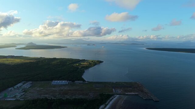 Ba&iacute;a de Paranagu&aacute;, Paran&aacute;, Brazil, with large container cargo ships navigating the approach channel toward the Port of Paranagu&aacute;, surrounded by islands and coastline, drone slow gliding