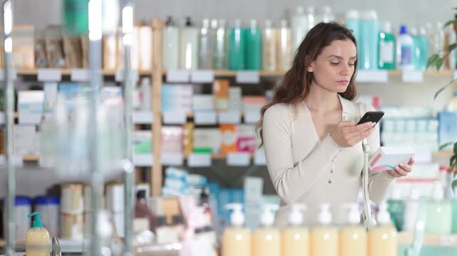 Woman in pharmacy scans QR code on omega 3 supplement. Health care, healthy lifestyle, prevention. Dietary supplements, replenishment of vitamin and microelement deficiencies.