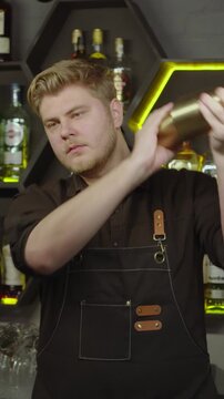 Bartender mixing ingredients in a metal shaker