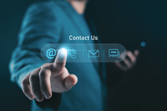 Businessman pressing virtual contact us button with email, phone and chat icons on digital interface. Customer support, online communication and help desk concept for corporate service.