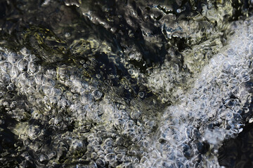 Close-Up of Bubbling Water Flowing Over Rocks in Nature