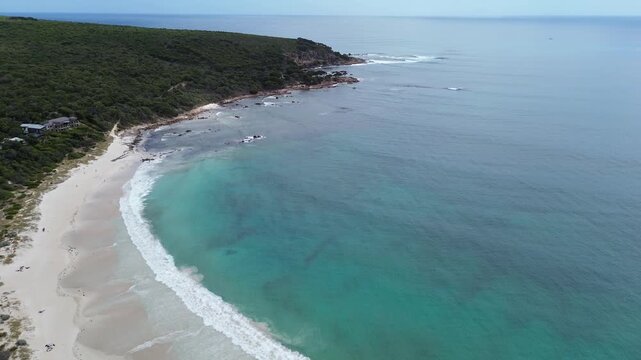 Aerial View of Bunker Bay beach and luxury resort in Western Australia. Sunny coastal travel footage, white sandy beaches, pure blue water with crashing waves. Partly cludy sky