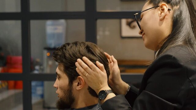 Hairdresser using comb and scissors for man haircut