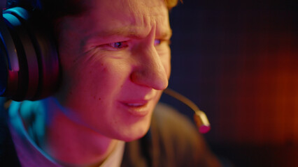 Young teen streamer gamer man play fail online video computer game. Esport concept virtual entertainment. Cyber e sport videogame tournament live stream. Neon light. Tense player loss competition. © Татьяна Епанешникова