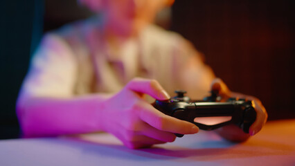 Young teen girl streamer gamer woman playing online video game on computer use joystick. Gaming console virtual entertainment. Cyber e sport videogame controller. Neon light. Tense player hold joypad. © Татьяна Епанешникова