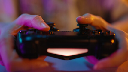 Young teen girl streamer gamer woman playing online video game on computer use joystick. Gaming console virtual entertainment. Cyber e sport videogame controller. Neon light. Tense player hold joypad. © Татьяна Епанешникова