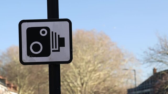 Traffic camera sign with blurred city background