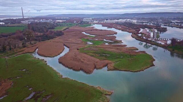 Wetlands and estuary of Bassin Carnot with the Pont de Normandie near Honfleur, France. Aerial forward