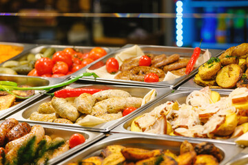 Obraz premium Variety of hot buffet food grilled sausages roasted potatoes vegetables and vibrant spices