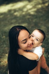 Fototapeta premium Loving mother embracing her happy little child outdoors