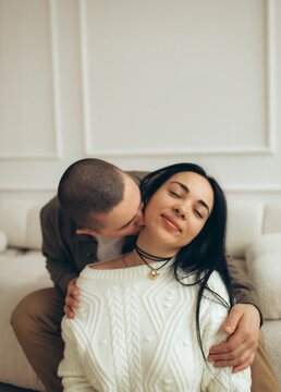 Loving couple sharing intimate moment on cozy sofa