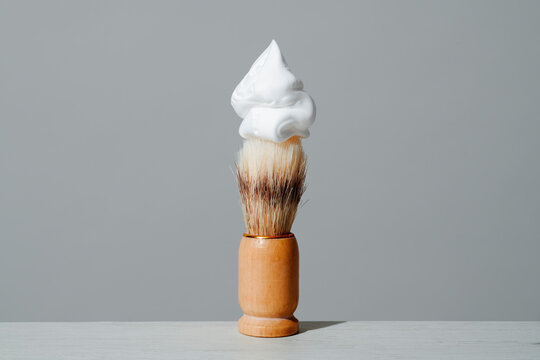 Shaving brush with foam in minimalist bathroom setting