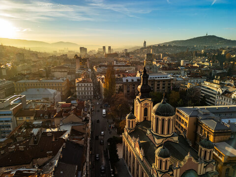 Aerial view of the Orthodox Cathedral in Sarajevo with modern skyscrapers in the distance, contrast of historic architecture and contemporary business district, Bosnia and Herzegovina, 4K
