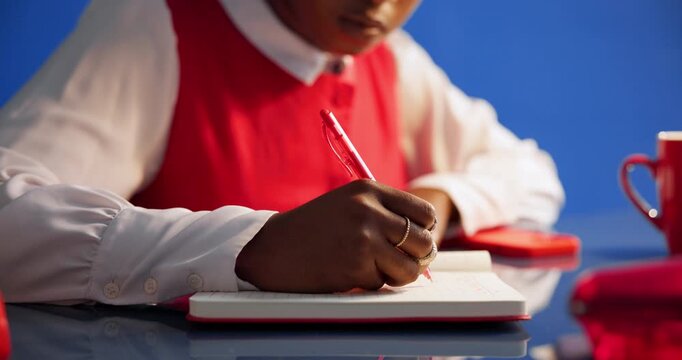 Woman, hands and writing with book in studio for schedule planning on a blue background. Closeup, female person or taking notes with diary or notebooks for deadline reminder, agenda or daily tasks