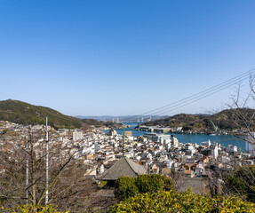瀬戸内しまなみ海道の玄関口：尾道大橋と青い海、活気ある港町、映画のような街並み