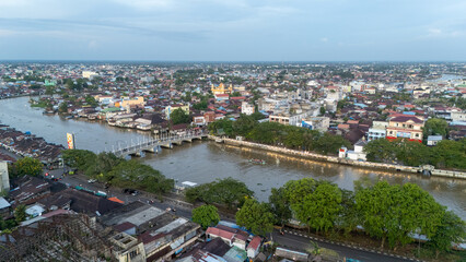 Obraz premium Banjarmasin city with its river, buildings, and the 0KM monument visible from above