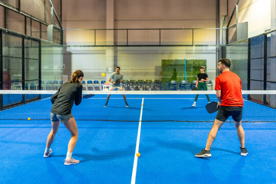 People playing pickleball doubles match on indoor court