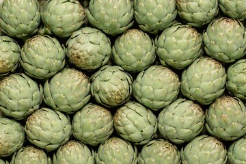 Fresh artichokes flat lay macro texture top view.