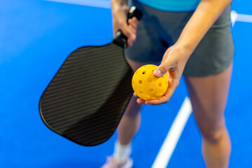 Fototapeta premium Athlete holding pickleball paddle and yellow ball