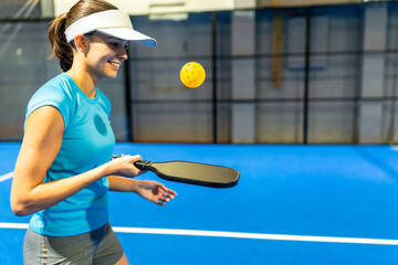 Young woman enjoying a pickleball game on court