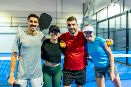 Four happy friends posing after pickleball game
