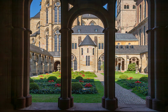 Cloister courtyard view at Trier Cathedral in Trier, Germany, framed by arches and columns; UNESCO World Heritage site with historic church architecture and garden.