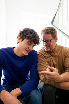 Father and son bonding at home with keys to a new flat