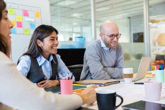 Coworkers sharing a funny moment during a team discussion at the office